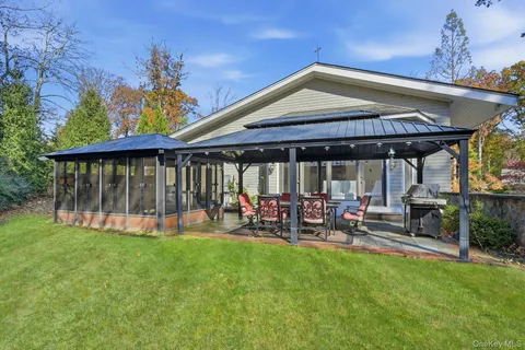 a view of a house with a backyard and sitting area