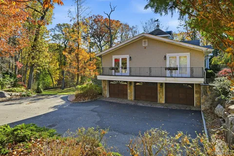 a front view of house with yard and trees in the background
