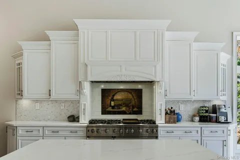 a kitchen with white cabinets and appliances
