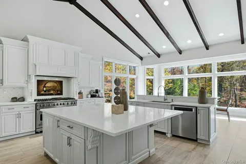 a kitchen with stainless steel appliances granite countertop a sink a stove and a wooden floors