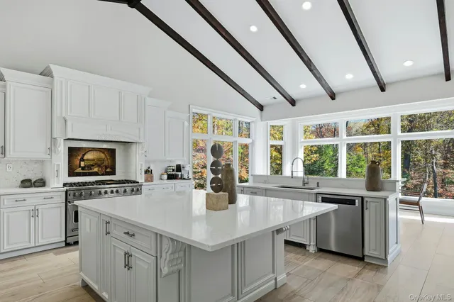 a kitchen with stainless steel appliances granite countertop a sink a stove and a wooden floors