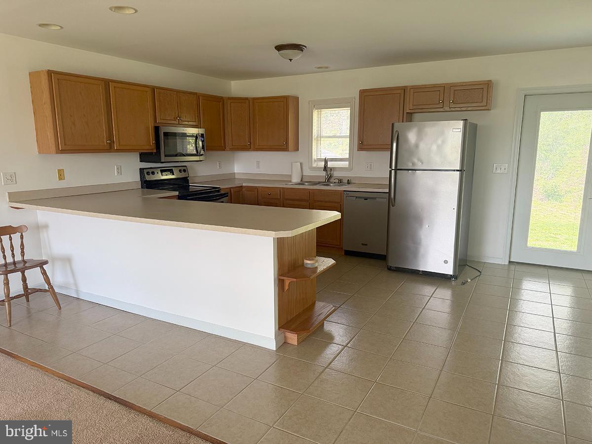 1121 Montour Road Loysville, PA 17047 - Photo 4 of 20 a kitchen with a refrigerator a stove top oven a sink and cabinets