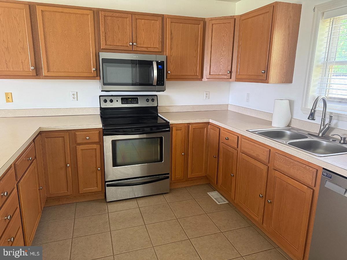 1121 Montour Road Loysville, PA 17047 - Photo 6 of 20 a kitchen with granite countertop a stove top oven microwave and cabinets