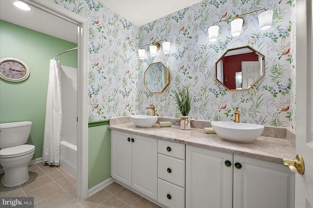 a bathroom with a granite countertop sink toilet a mirror and bathtub