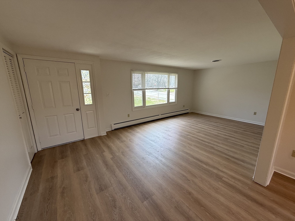 1 Joyce Road Peabody, MA 01960 - Photo 2 of 12 an empty room with wooden floor and windows