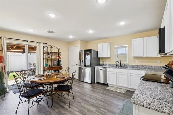 a kitchen with refrigerator and chairs