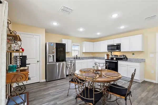 a kitchen with granite countertop stainless steel appliances a sink and a refrigerator