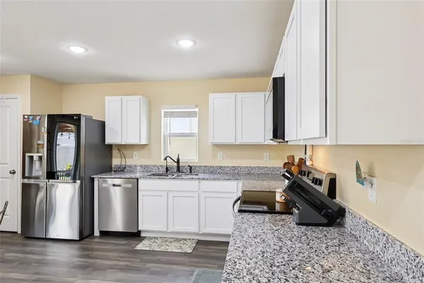 a kitchen with stainless steel appliances granite countertop a sink stove and refrigerator