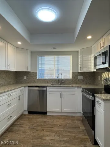 a kitchen with stainless steel appliances granite countertop a sink and cabinets
