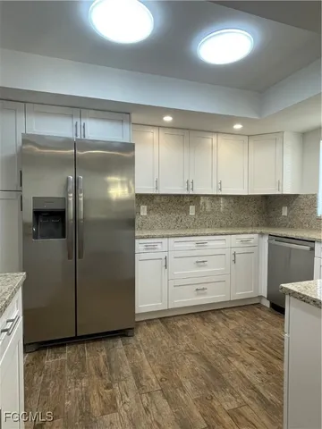 a kitchen with a refrigerator sink and cabinets