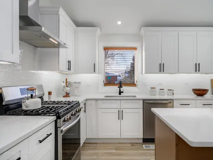 a kitchen with a sink a stove and cabinets