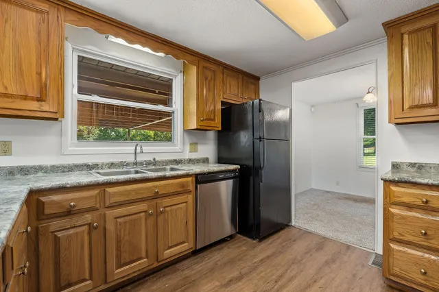 a kitchen with stainless steel appliances granite countertop a refrigerator and a sink