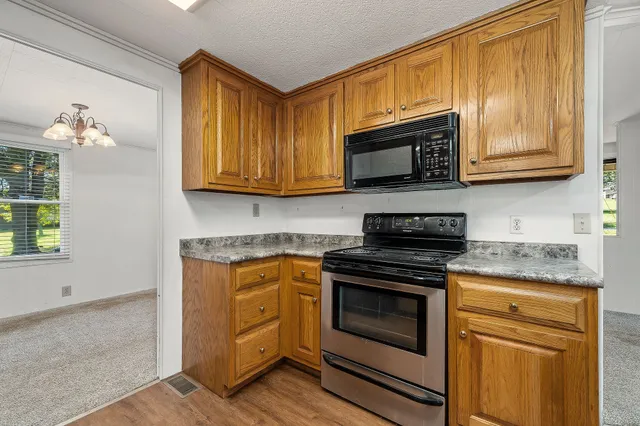 a kitchen with granite countertop cabinets stainless steel appliances and a window