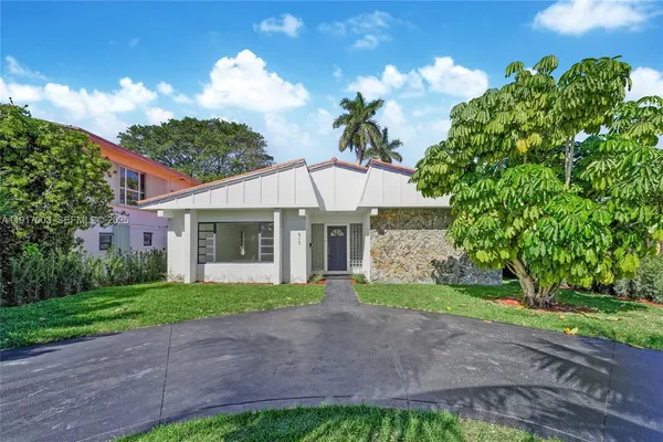 a front view of a house with a yard and a garden