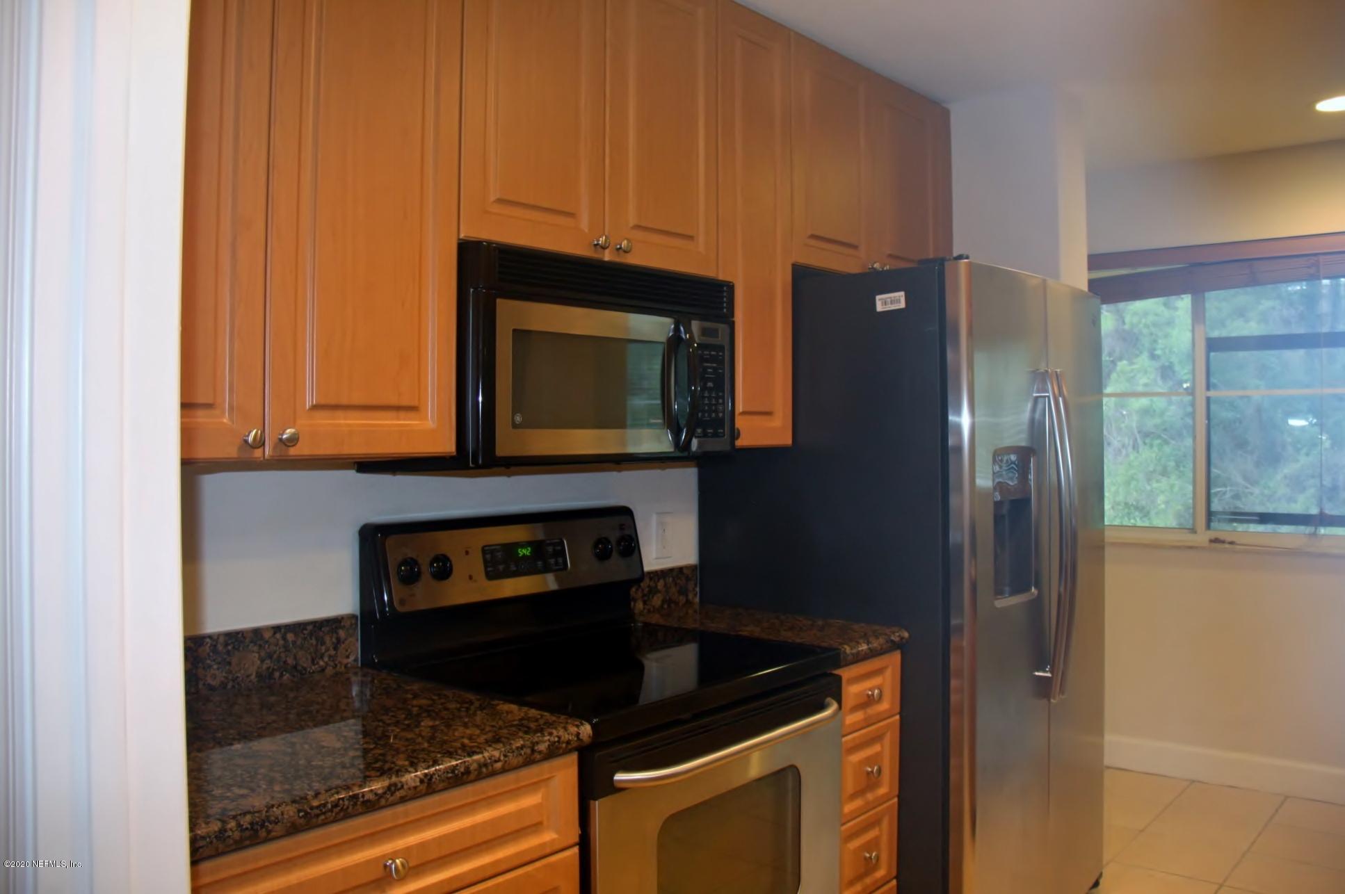 9745 Touchton Road, Unit 2401 Jacksonville, FL 32246 - Photo 20 of 50 a kitchen with granite countertop a refrigerator stove and microwave