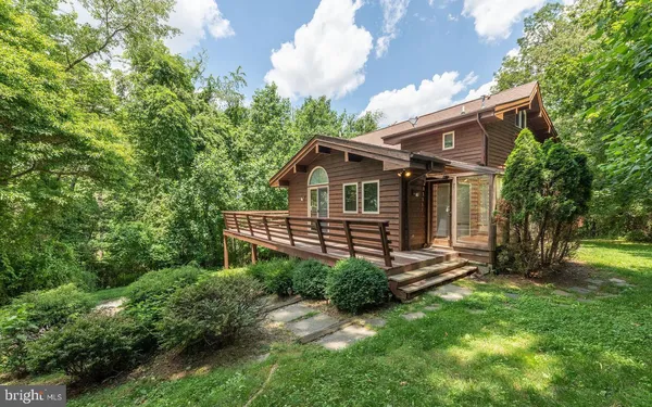 a view of a house with a small yard and a large tree