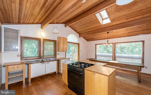 a kitchen with stainless steel appliances granite countertop a stove and a large window