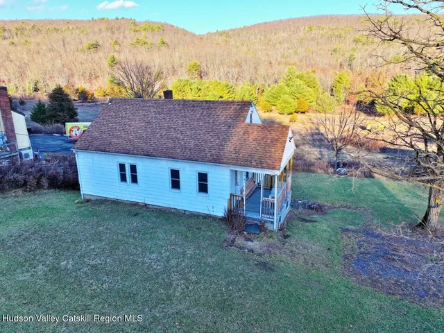 a view of backyard with swimming pool and seating space