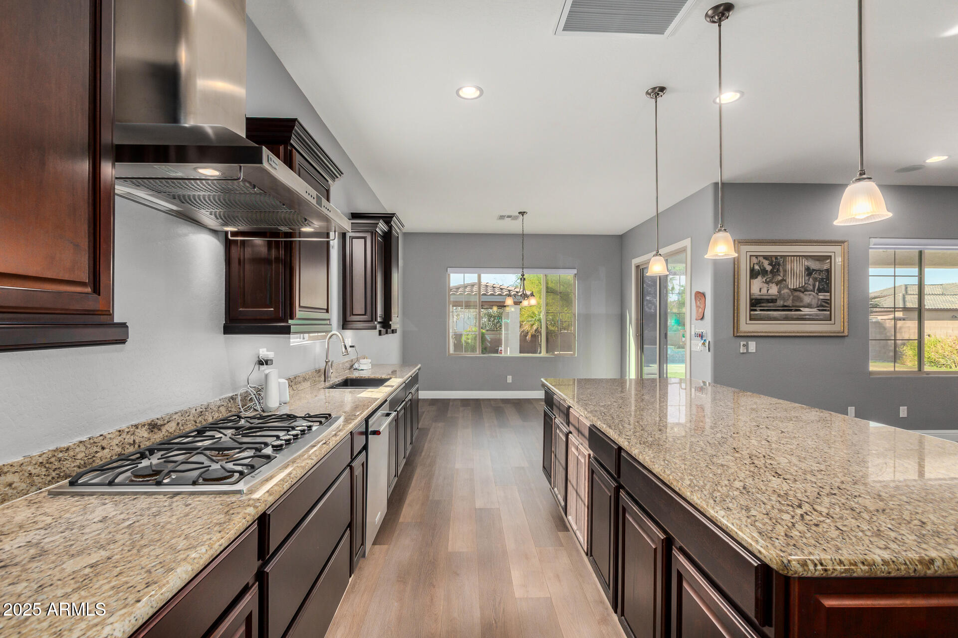 1672 South Sunset Drive Chandler, AZ 85286 - Photo 19 of 68 a kitchen with stainless steel appliances granite countertop a lot of counter space and wooden floor