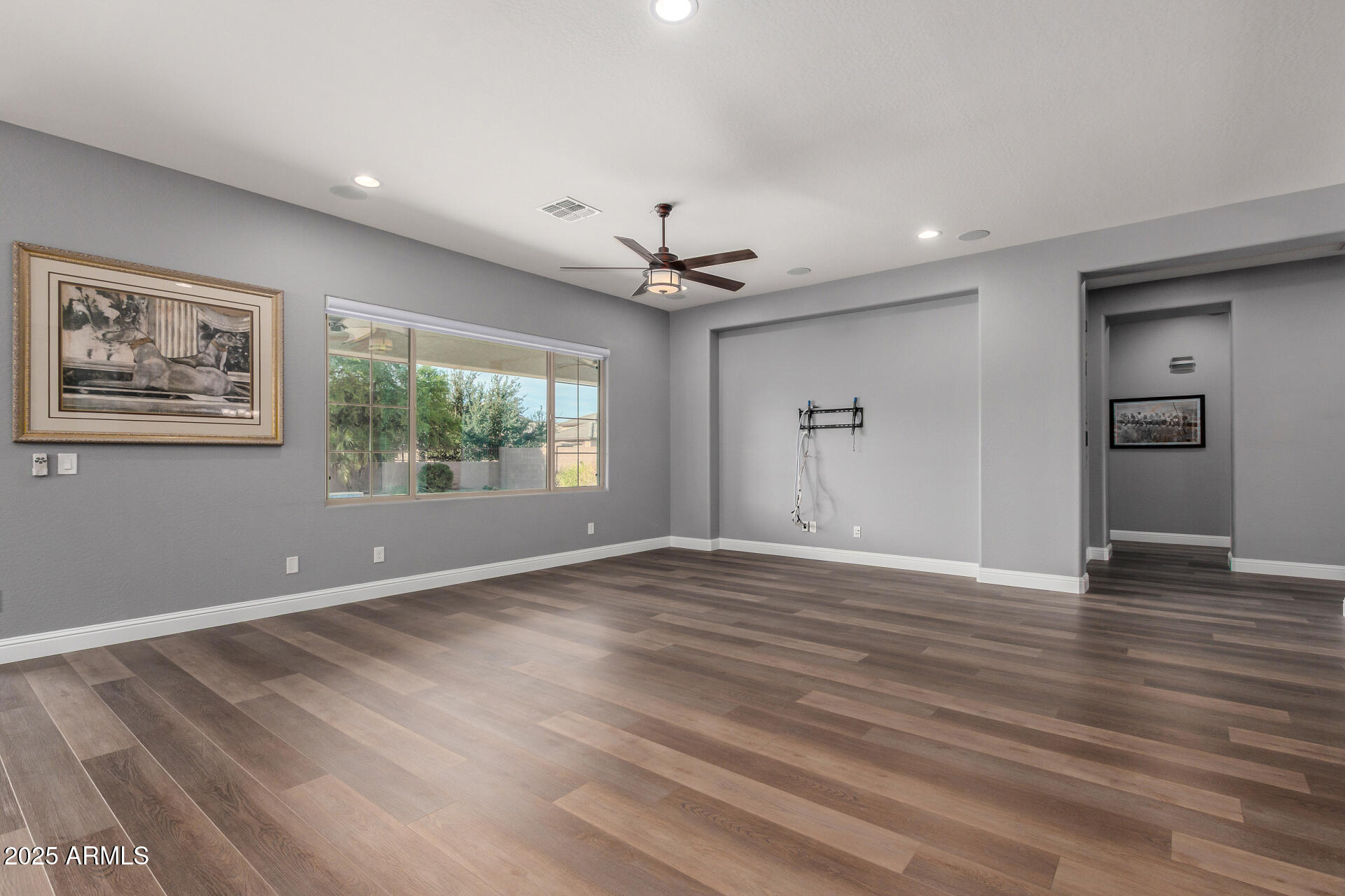 1672 South Sunset Drive Chandler, AZ 85286 - Photo 7 of 68 a view of an empty room with a window and wooden floor