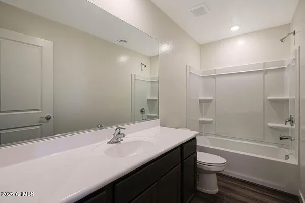 a bathroom with a granite countertop sink a toilet and shower