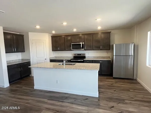 a kitchen with stainless steel appliances granite countertop a refrigerator a stove a sink and a microwave