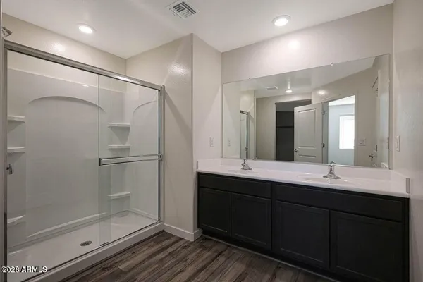 a bathroom with a double vanity sink mirror and shower