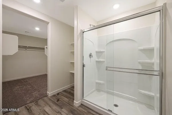 a bathroom with a glass shower door and a glass door