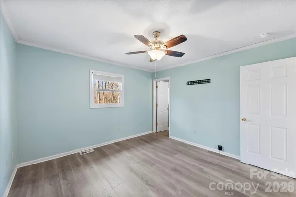a view of a big room with wooden floor and a ceiling fan