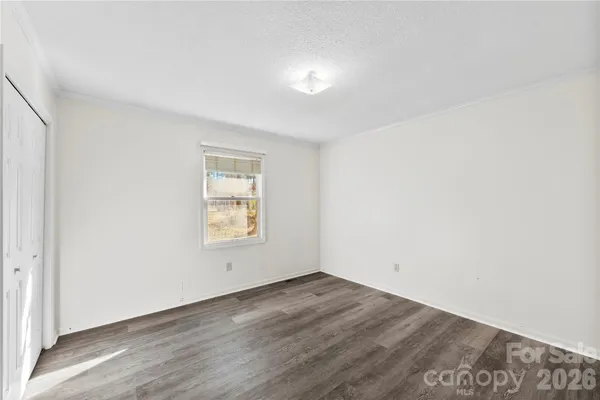 an empty room with wooden floor and window
