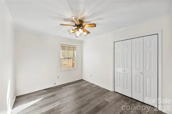 an empty room with a window and a ceiling fan