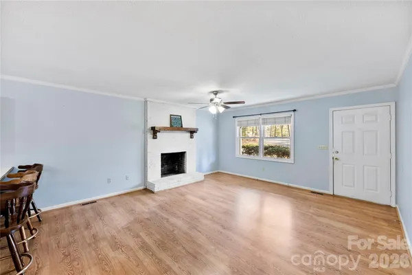 a view of empty room with fireplace and windows