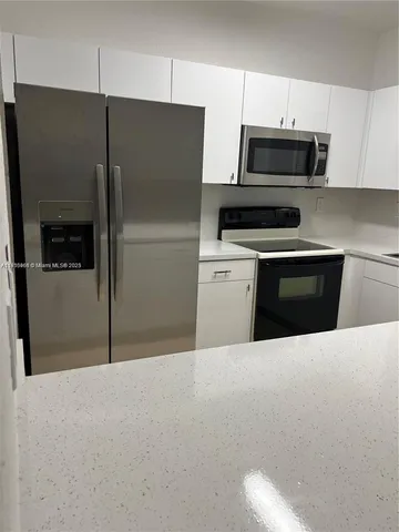 a kitchen with stainless steel appliances a refrigerator sink and microwave