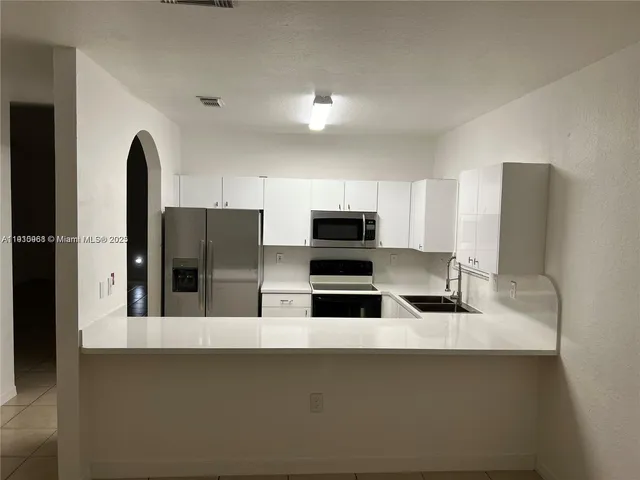 a kitchen with stainless steel appliances a sink a stove top oven and cabinets