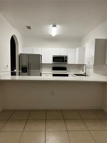 a view of an empty room and a bathroom