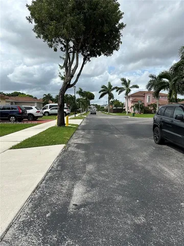 a view of a street with houses on both side of the road