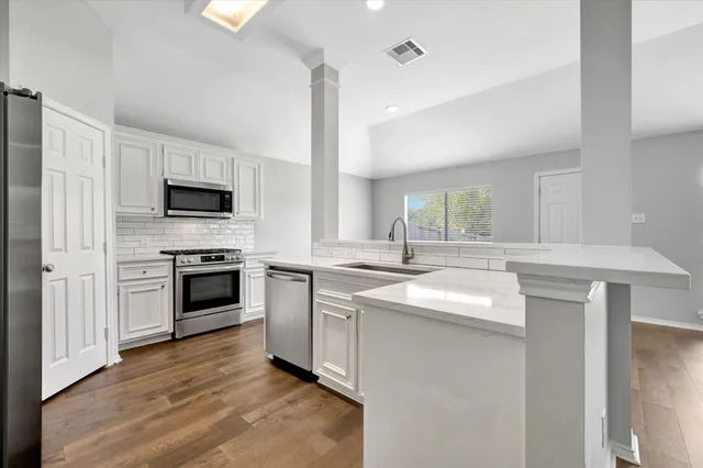 a kitchen with a sink stove and microwave