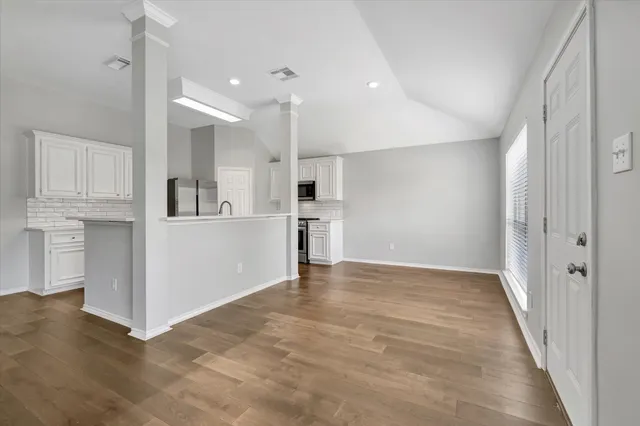 an empty room with kitchen appliances and windows
