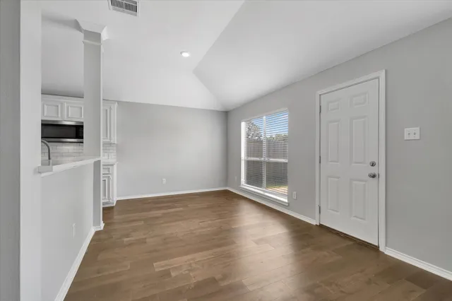 wooden floor in an empty room with a window