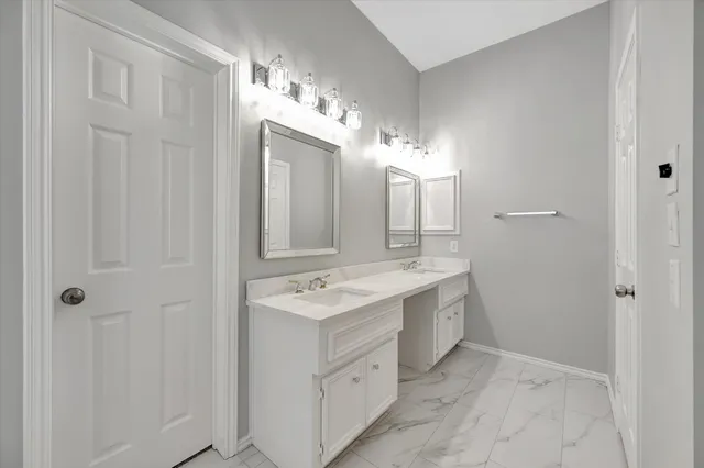 a spacious bathroom with a double vanity sink a mirror and a shower