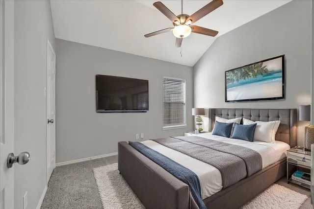 a bedroom with a bed and a ceiling fan