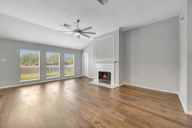 a view of empty room with wooden floor and fireplace