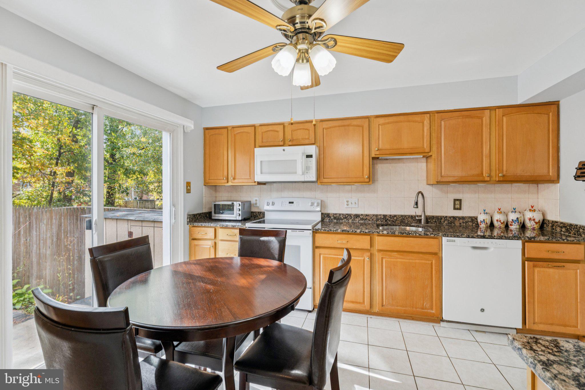 7029 Bradwood Court Springfield, VA 22151 - Photo 12 of 43 a kitchen with granite countertop a stove a sink a dining table and chairs