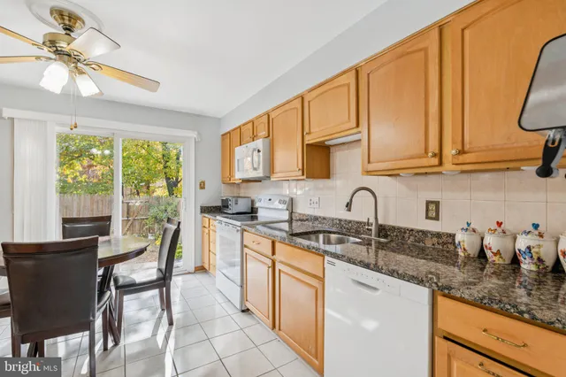 a kitchen with stainless steel appliances granite countertop a stove a sink dishwasher and cabinets with wooden floor