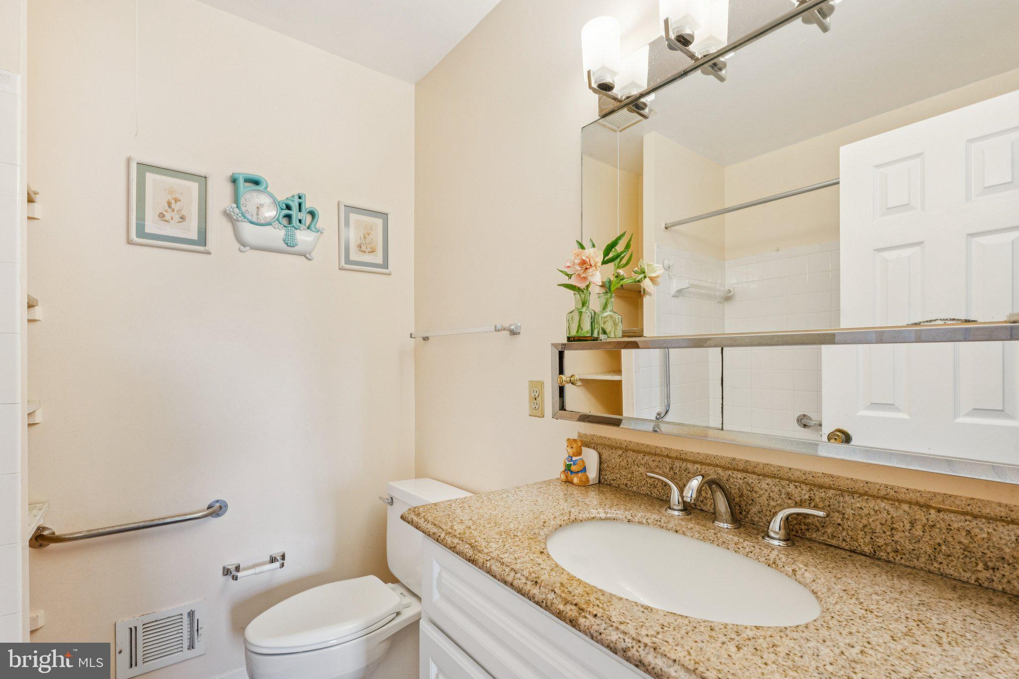 7029 Bradwood Court Springfield, VA 22151 - Photo 22 of 43 a bathroom with a granite countertop sink a toilet and a mirror