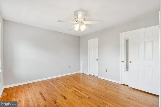 a view of a room with wooden floor and ceiling fan