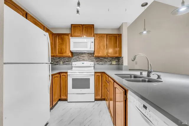 a kitchen with stainless steel appliances granite countertop a sink and a refrigerator