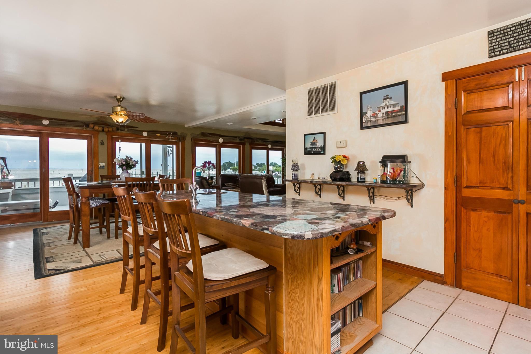 9103 Cuckold Point Road Baltimore, MD 21219 - Photo 6 of 28 a kitchen with stainless steel appliances granite countertop dining table chairs and view of living room