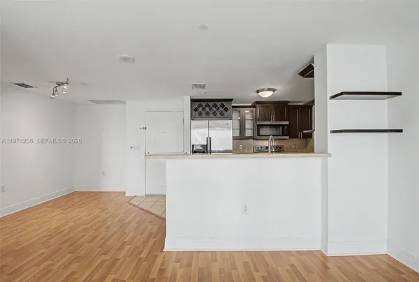 a kitchen with granite countertop a refrigerator and a stove top oven