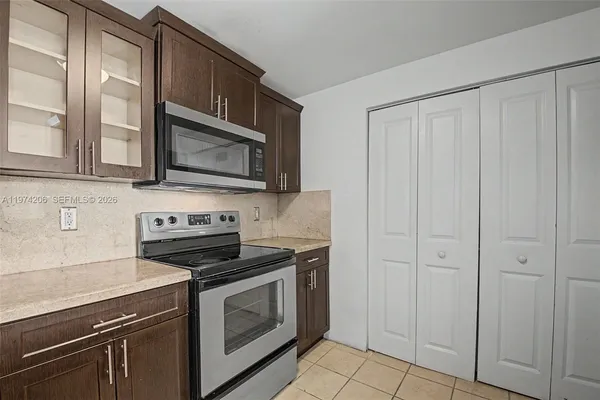 a kitchen with granite countertop white cabinets stainless steel appliances and sink